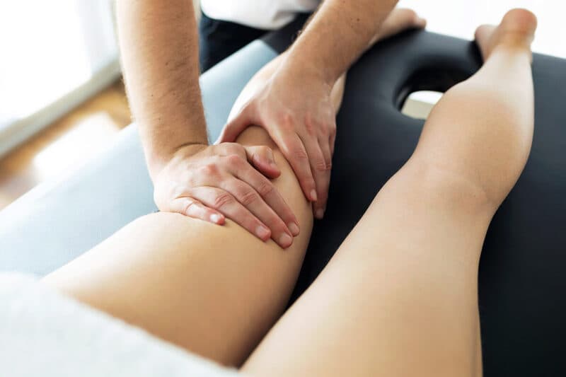 Physiotherapist treating a patient's leg on a treatment table